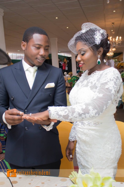 nigerian groom slipping ring into bride's finger