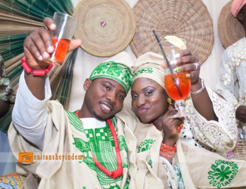 yoruba couple in green aso-oke toasting to a drink